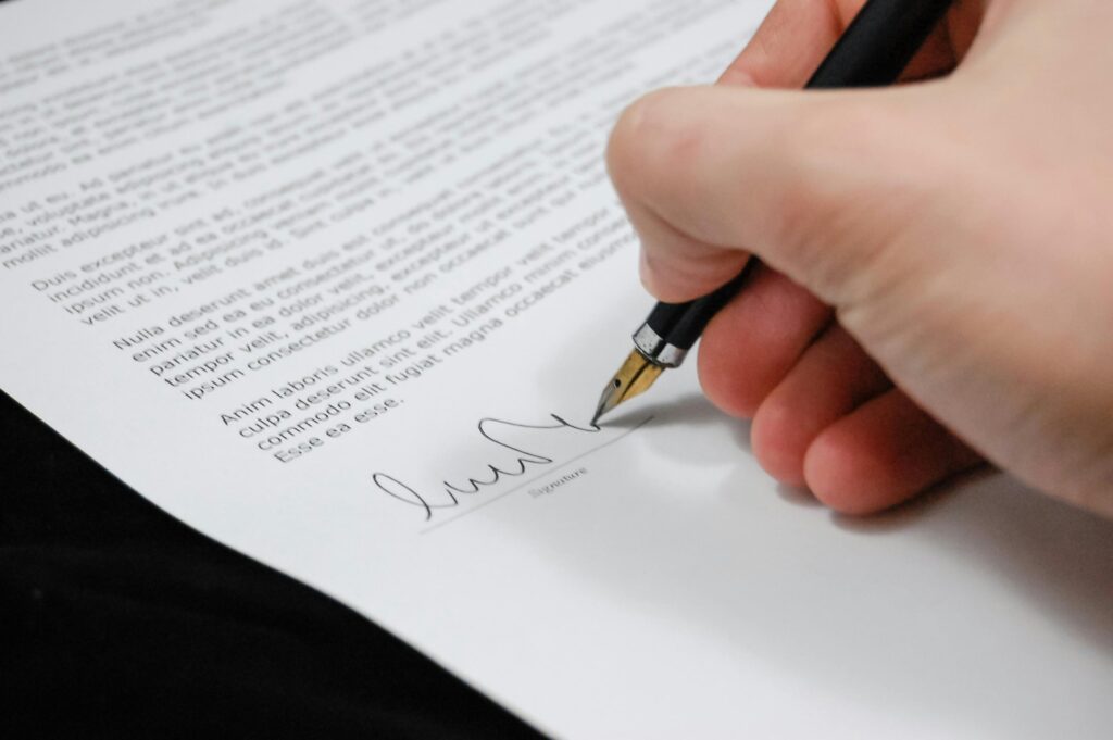 document agreement documents sign 48148 48148 Close-up of a hand signing a legal document with a fountain pen, symbolizing signature and agreement.